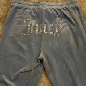 Blåa Juicy byxor - Blåa juicy byxor med fickor som har dragkedja, köpta på juicy coutures egna hemsida. Är i stolek L och är i jättebraskick och år lång i benen. Är använda fåtal gånger.