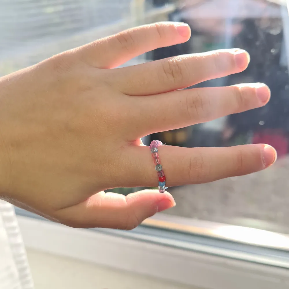 En fin ring som är gjord av ståltråd och pärlor. Accessoarer.