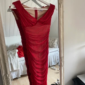 Röd klänning - Röd klänning från OhPolly. Använd 2 gånger, passar mig med stor byst och storlek S. Ser bättre ut på kroppen än på bilden då den är väldigt stretchig. 