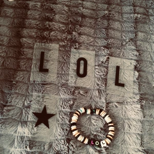 Armband  - Den kan lysa i mörkret och så är den Guldig och så är den svart och så står  det LOL på den och den har ett grönt band