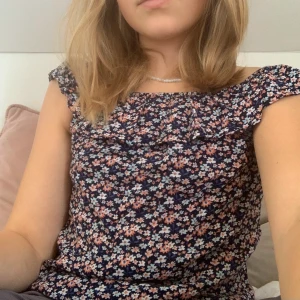 Blommig tröja  - En blommig tröja med volang över axlarna 