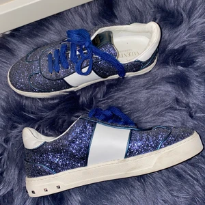 Valentino skor - Valentino Garavani glitter flycrew sneakers!!! Finns inte att köpa längre så de blir UNIKA!!! I snyggaste blå färgen som livar upp vilken outfit som helst. Sjukt snygga. Nypris 6000 kr. Väldigt bra skick, inga nitar borta!! Storlek 39.5. Äkthetsbevis finns 🌠🌠🌠