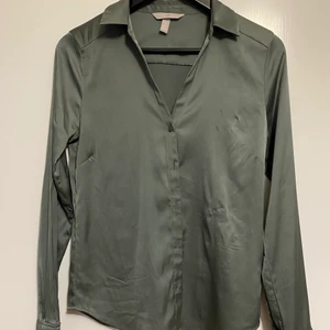 H&M skjorta  - H&M grön, siden skjorta i storleken S, ok skick då jag råkade bränna den lite med strykjärn på vänster sida. Man ser väldigt lite. Använts bara 1 gång innan händelsen.
