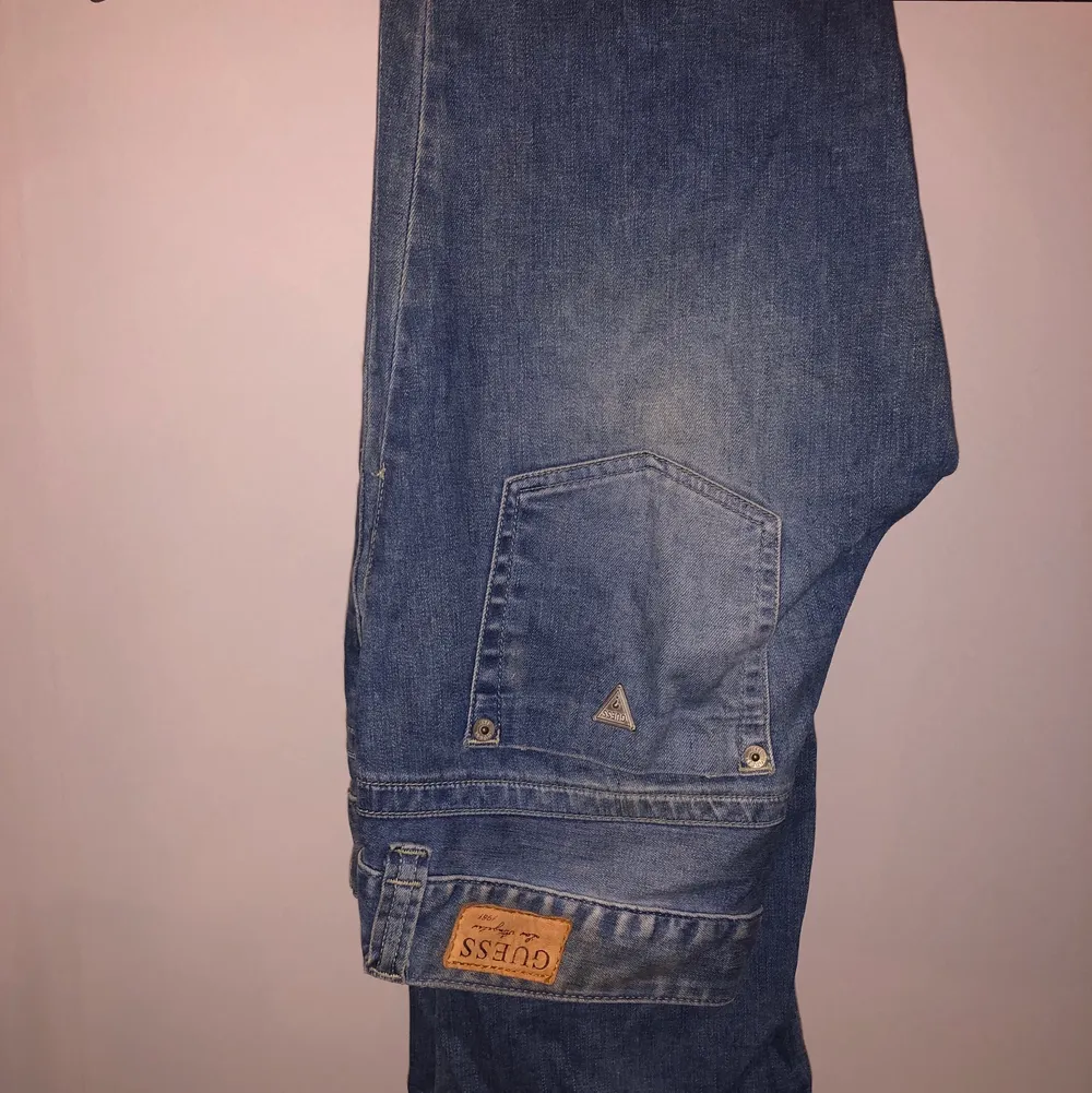 Ett par vintage bootcut guess jeans från sent 90tal. Lågmidjade med balla slitningar på båda låren. Sjukt fina och trendiga!. Jeans & Byxor.