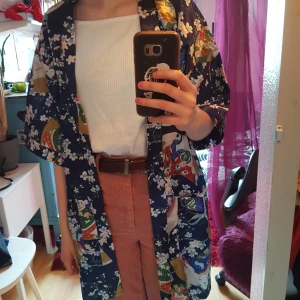Morgonrock i japansk stil - Kort morgonrock, kimono? Köpt på second hand. Klara fina färger i ett sidenliknande material. Skärpet saknas tyvärr men tycker den funkar bra öppen! Märkt M men passar säkert en S också.