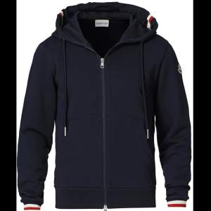 En Marinblå moncler zip hoodie, skick 9/10. Dragkedjan är lite trög längst toppen vilket beror på en söm som är lite sönder. Annars mycket fin. Storlek L