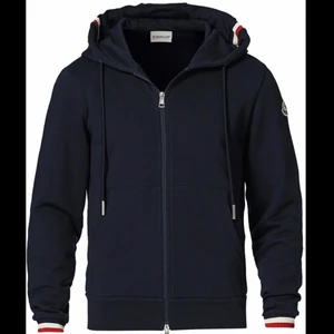 Marinblå Moncler zip hoodie - En Marinblå moncler zip hoodie, skick 9/10. Dragkedjan är lite trög längst toppen vilket beror på en söm som är lite sönder. Annars mycket fin. Storlek L