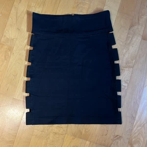 Dimepiece svart kjol  - Sexig svart Hugh waisted kjol med snygga detaljer på sidorna där man ser hud, fungerar bra med strong trosor under. Passar till kortare top eller blus. Materialet är stretchigt och skönt att ha på sig!