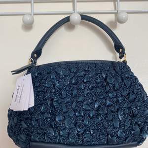Navy blue small genuine leather handbag. Textured fabric. Short handles and zip. Unused with label. Original price 790kr.