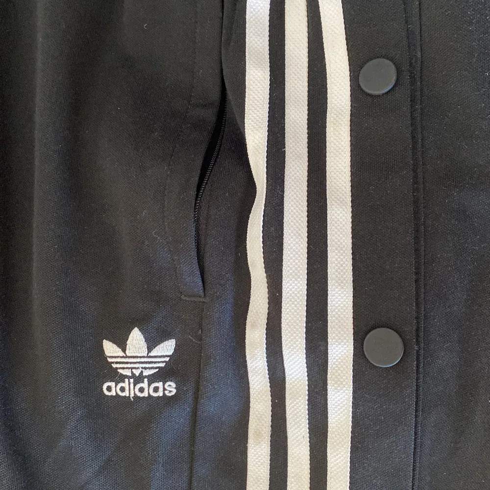 Adidas popper pants med knappar längst båda benen. Funkar att knäppa upp några och ha en lite mer flowy passform på byxorna! Storlek S. Finns att hämtas upp i Uppsala eller skickas mot porto (66kr med postnord frakta lätt). Jeans & Byxor.