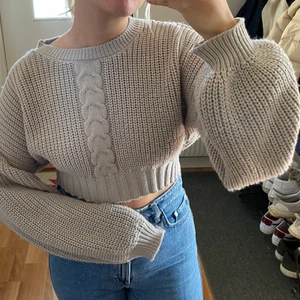 Kort stickad tröja från NA-KD - Croppad stickad grå/beige tröja från NA-KD i fint skick! Använd ett par gånger. Inte stickig utan mjuk och skön. 150+frakt 66kr