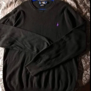 Ralph Lauren, tröja (herr)  - Ralph Lauren svart långärmad tröja med lila märke. Stl. L, Slim fit. Beg. i fint skick. 