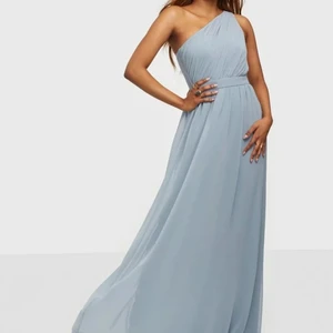 Oanvänd balklänning från Nelly i strl 38 - En oanvänd och mycket vacker klänning från Nelly med prislappen kvar! Klänningen har en påsydd underkjol och är därmed inte genomskinlig. Skriv gärna för fler bilder :)