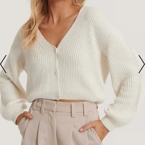 Vit kofta från NA-KD✨ - Vit stickad kofta från NA-KD✨ säljer då den är för liten på mig som är en M/L. Använd men i fint skick! Kan skicka fler bilder🌟 frakt tillkommer och priset kan diskuteras (Första bilden är lånad från NA-KD)