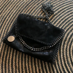 Handväska🌸 - Säljer denna snygga svarta väska med Kjelle detaljer för 200kr men priset kan diskuteras:) köpte denna för 250kr. Säljer denna för att den tyvärr inte kom till användning. Den ser väldigt glittrig ut men det är inget som stör:) köpt hör på Plick🫶🏼