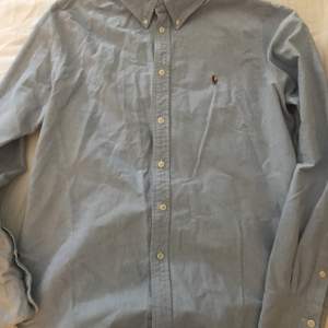 Långärmad ljusblå Ralph Lauren skjorta i storlek S/M. Bra skick använd fåtal gånger. 