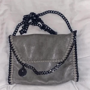Stella McCartney väska  - Intressekoll på min Stella McCortney liknande väska i grå. Mycket bra skick o man får plats med allt. BUD PÅ 450kr