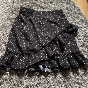 Kjol - En svart volangkjol med prickar på