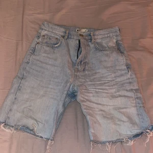 Långa highwaist jeansshorts - Ett par highwaist ljusblå jeansshorts från gina tricot. De är väldigt fina och ser skrynkliga ut på bilden då den legat i min garderob hur länge som helst. 