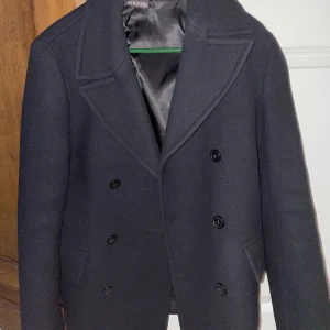 Douglas Enocssons Skepparrock - Nyfunnen och väldigt eftertraktad skepparrock i svart. Storlek M och i allmänt gott skick. Inköpt för cirka 100 kr för 3 år sedan. Budgivning sker.