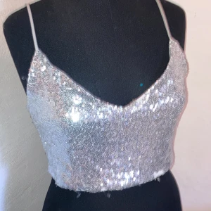 Glitter topp - En superfin glitter topp i silver! Perfekt till fest. Den har några få defekter därav kan ni få det till ett mycket billigare pris än vad jag köpte den för.
