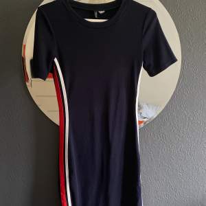 Mörkblå klänning med rött och vitt sträck i sidan från h&m divided. Sitter tight och former kroppen fint! Köpt 2019 och är inte använd sedan dess. Lappen är sönder (se bild 3) så storleken är jag osäker på, 36 eller 38. 100 kr + frakt (MAX 50kr)