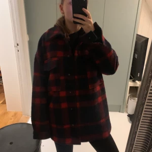 Rutig kappa - Marinblå/rödrutig kappa, den har en del noppror men är fortfarande fin!