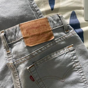 Lågmidjade Levis jeans - Lågmidjade levis jeans i en ljusblå färg. Raka jeans som är lite utsvängda längst ner. Det står ingen storlek men passa som S/XS. 