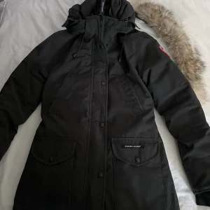 Canada Goose Jacka - Jag säljer då min fina och varma canada goose jacka, då jag har köpt en ny vinterjacka och därav inte har nån användning av denna längre. Den är riktigt varm och skön. ☺️(har några få fläckar men som säkert lätt kan tvättas bort)