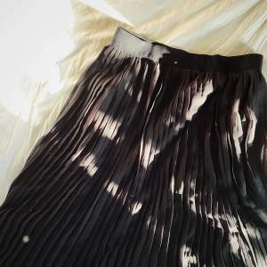 Det perfekta plagget. En svart plisserad kjol. 
