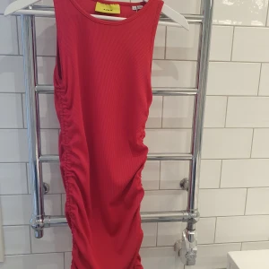 ROSA JJXX KLÄNNING - Tajt rosa klänning med scrunchsnören vid kjolsslutet. Med dessa kan man göra den kortare. Strl M.  Färgen är mer rosa än vad som syns på bild.   Aldrig använd 