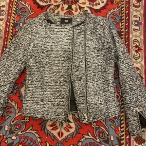 Grå sommarjacka storlek 34 - En grå sommarjacka från H&M med detaljer i form av dragkedjor på ärmarna. Använt några gånger men i gott skick.   Säljer för 100kr   Jag kan mötas upp i Stockholm men även skicka jackan, du står dock för frakt.