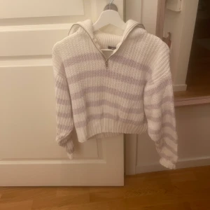 Stickad tröja  - Stickad tröja från Gina Tricot, använd fåtal gånger. Vit & lila randig