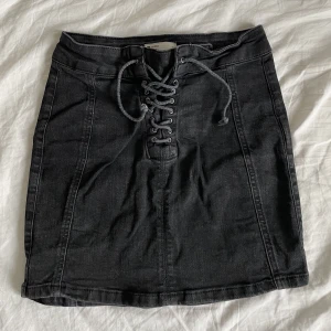 Svart jeans kjol - Stretchig och kjolen sitter ”mid waist”  Snörningen där framme kan du justa själv 