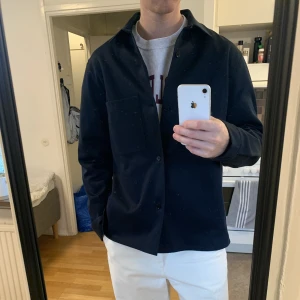 ARKET Overshirt i twill - Oanvänd overshirt från ARKET i twill. Relaxed fit. Storlek 52. Jag är 193cm och väger ca 85kg. Är ganska kraftigt tyg så bra att använda som jacka med. Nypris 990kr. Kan både skickas till dig och mötas upp i Göteborg.