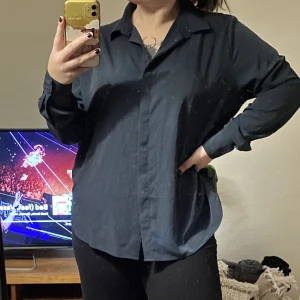 Skjorta - Den e mörkgrön med lite guld detaljer, siden aktig i materialet. (ursäkta smutsig spegel)