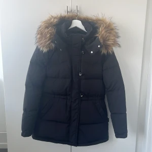 Hollies Ariana dunjacka - Dunjacka från Hollies, använd knappt 1 vinter, som ny!!🥰 Så varm och skön, kommer med tillhörande fukspäls krage(går att ta av). Köpt på Ellos. Nypris 4600kr OBS! Liten i storlek! Är som en 36/38