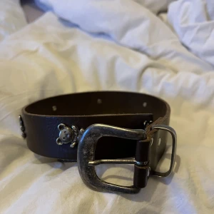  Skärp  - Jätte gulligt skärp med nallar på inga defekter men syns att det är använt passar mig som brukar ha 36-38 i byxorna om det är något hjälp med längden på skärpet 