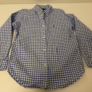 Vit och blå rutig skjorta, passar 7 åringar, 100% bommul, fint skick, som ny. Oxford skjorta button down.