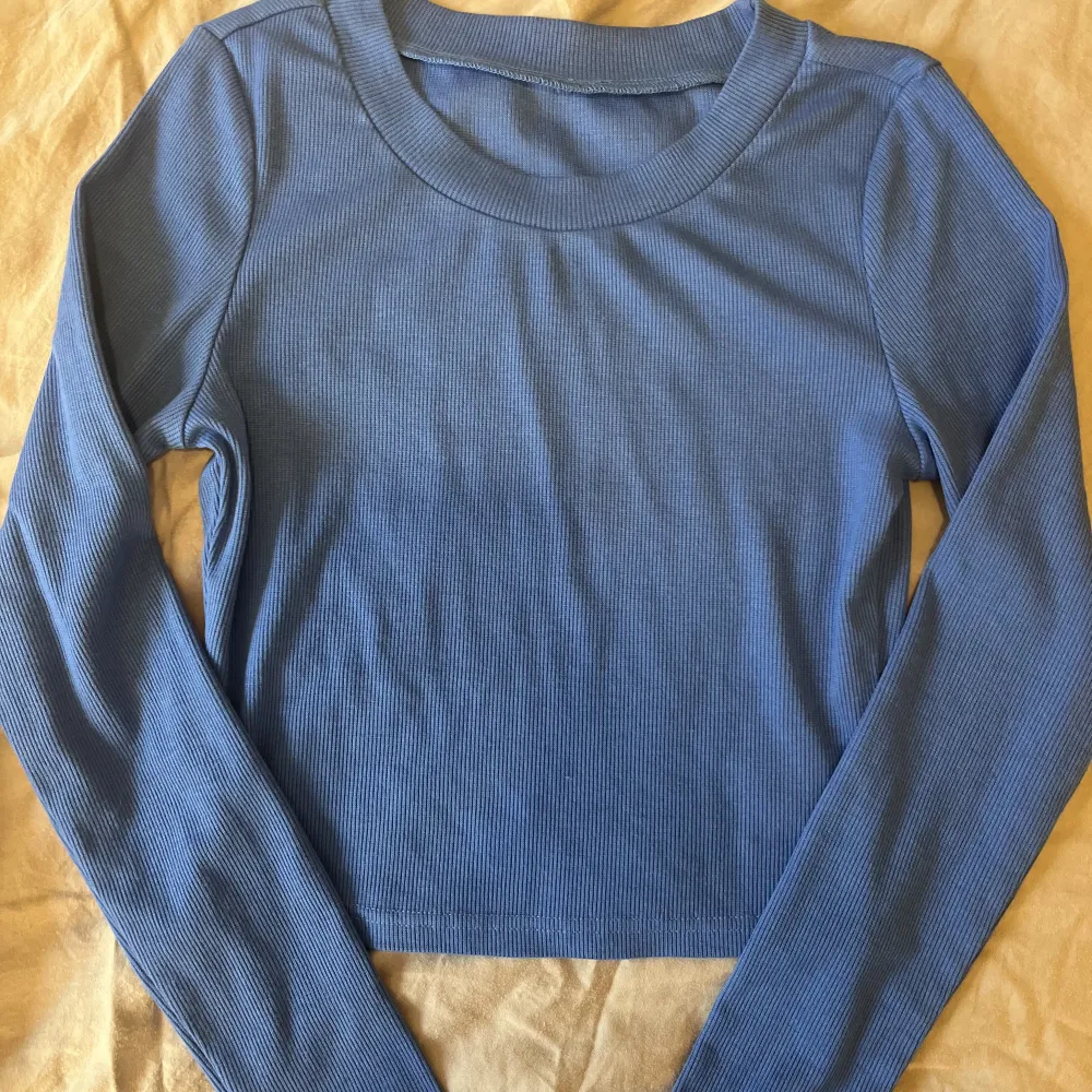 en ribbad mörkblå långärmad tröja i  stolek XS som jag köpte för någon månad sen men inte kommit till andvändning . Toppar.