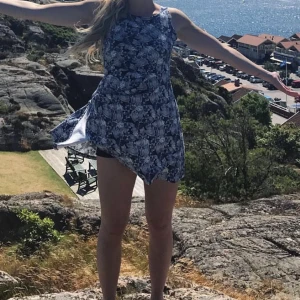 Klänning  - Blommig trikåklänning, färg navy med vitt mönster. Använd men hyfsat skick. Strl 160 (ungefär som strl 34, längd se bild - jag är 170 cm) 