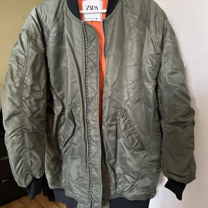 Bomberjacka - Orange inuti och mörkgrön utanpå. Strl xs/s men OS. Inga defekter :) köpt på Zara! 