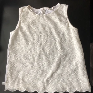 White no sleeve shirt with lace design size 13-14 (XS) - White shirt with a special beautiful design in the front, 3 layers (1st layer with the design, the 2nd is to cover under the design and 3rd from the back, plain white). It’s from a brand called LC Waikiki (size 13-14/158-164 cm)