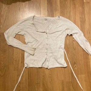 Söt kofta  - En söt liten kofta som man kan knyta i ryggen eller runt magen. Använt några gånger. Men helt okej skick. Den är beige 