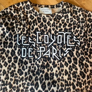 Leopardmönstrad märkeströja - Jag säljer denna supercoola märkeströja med leopardtryck. På framsidan är ett coolt texttryck med märkets namn. Tröjan är i väldigt bra skick och använd endast ett fåtal gånger! Observera dock en liten fläck vid texten som självklart påverkat priset!