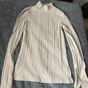 Ribbad tröja med slit strl S - En tröja knappt använd i bra skick. Ribbad med slit på både sidorna av midjan och vid ärmarna.
