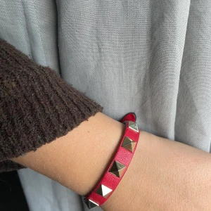 Valentino Armband  - Säljer mitt fina röda valentino armband. Armbandet är i väldigt bra skick, medföljande box, kvitto, äkthets bevis, dustbag och extra nitar (allt med följer)!❤️❤️❤️