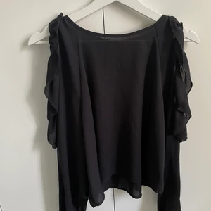 Blus från Gina med öppning för axlarna  - Snygg blus från Gina som är perfekt till fest och resturang, rak i passformen och rymlig! Ballongig i ärmarna där axlarna syns. 