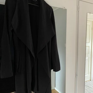 Kappa - Säljer denna svarta kappa som är i ett bra skick! Den är endast tråden som är sönder där bältet ska i som går helt enkelt att fixa. Storlek XS passar även S. Skickar fler bilder ifall det behövs!