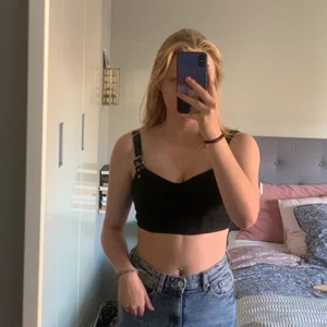 Topp med spännen - Topp med spännen från Hm, tyvärr alldeles för liten för mig med D kupor. Storlek 36. Man kan ändra axelbandens längd med spännena. Kan mötas i malmö samt frakta